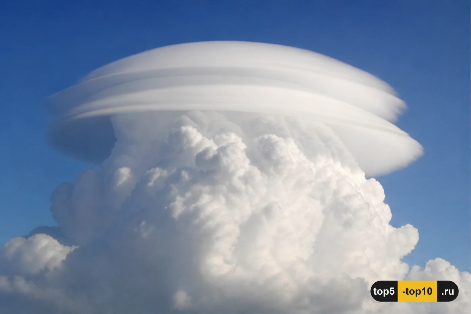 Облако pileus гладкой шапкой над растущей грозовой башней